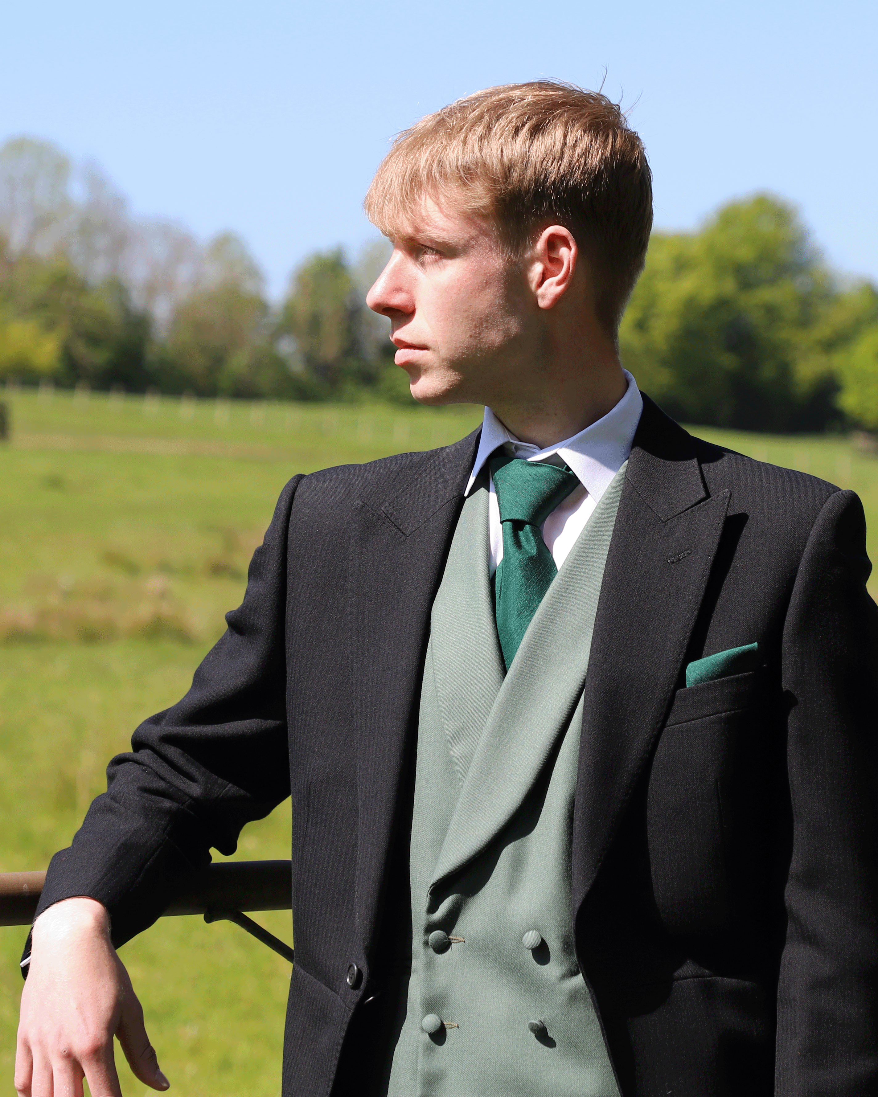 Model wears Black Tailcoat, Green Double Breasted & Grey Stripe Trousers Hire Package with Sage green Waistcoat with matching accessories