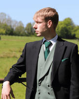 Model wears Black Tailcoat, Green Double Breasted & Grey Stripe Trousers Hire Package with Sage green Waistcoat with matching accessories