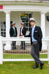 Three men in Royal Ascot attire standing on a grassy area with a white building in the background.