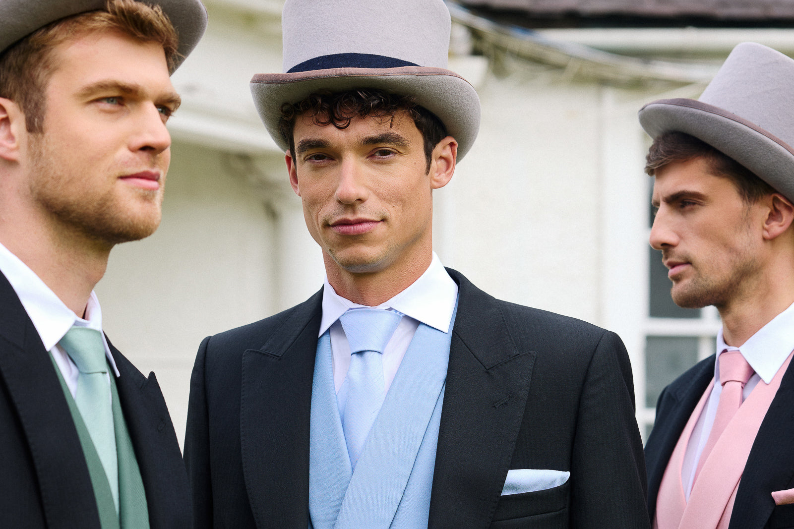 Three men in Royal Ascot attire with top hats standing outdoors.