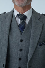 Gray tweed jacket with a patterned tie against a light gray background