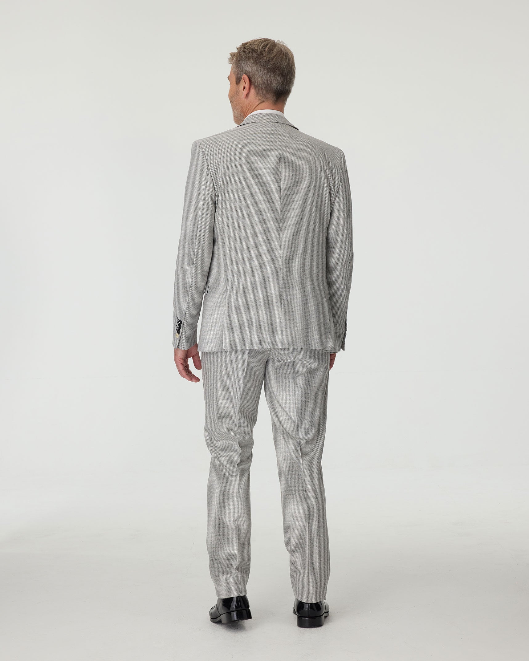 Man wearing a gray checkered suit on a white background