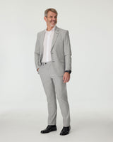 Man wearing a gray checkered suit with a white shirt on a white background