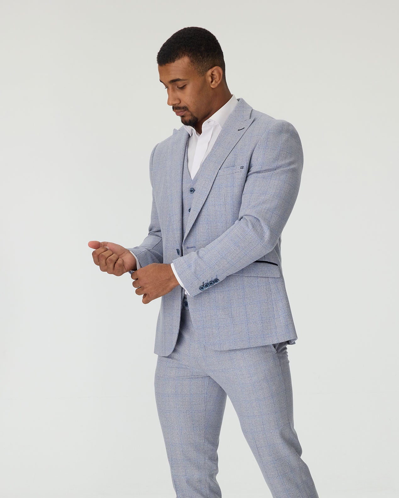 Man wearing a sky blue checkered suit on a white background