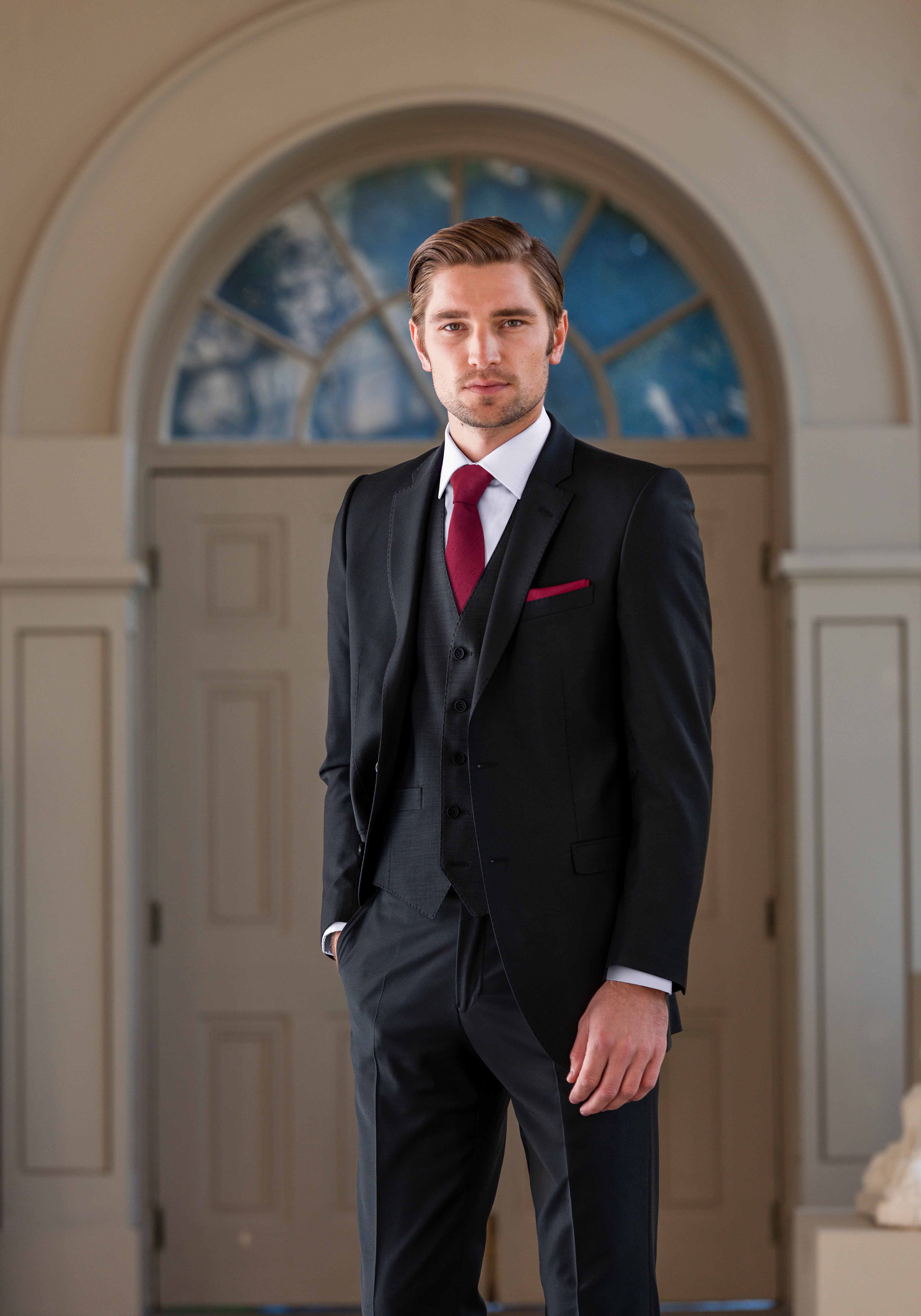 Full front view of black slim fit suit styled with red tie and pocket square for hire.